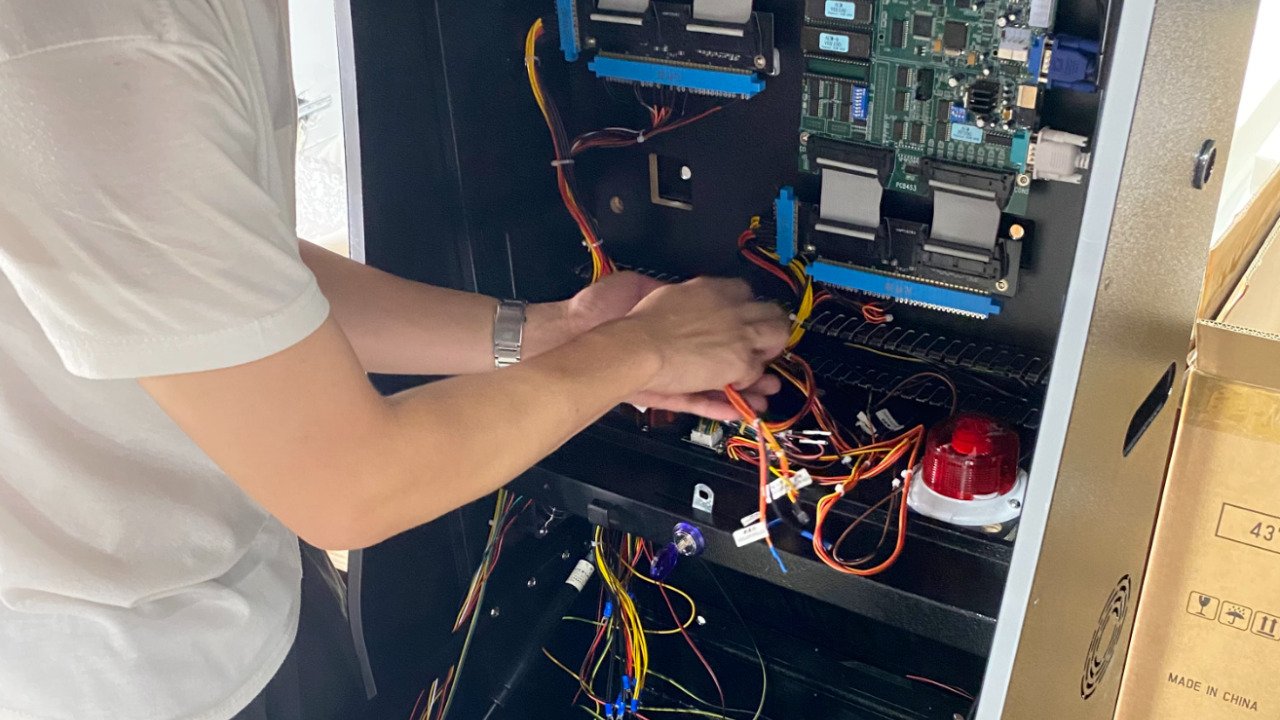 Technician connecting hardware wiring inside a cabinet